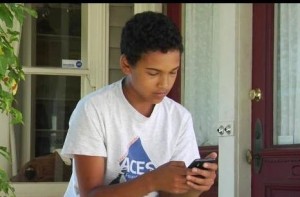 teen boy heads down in smartphone